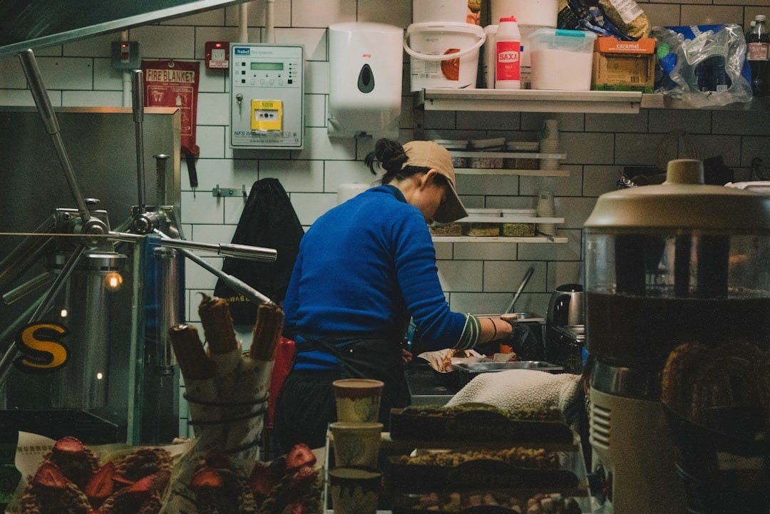 A person cooks in a busy restaurant kitchen.