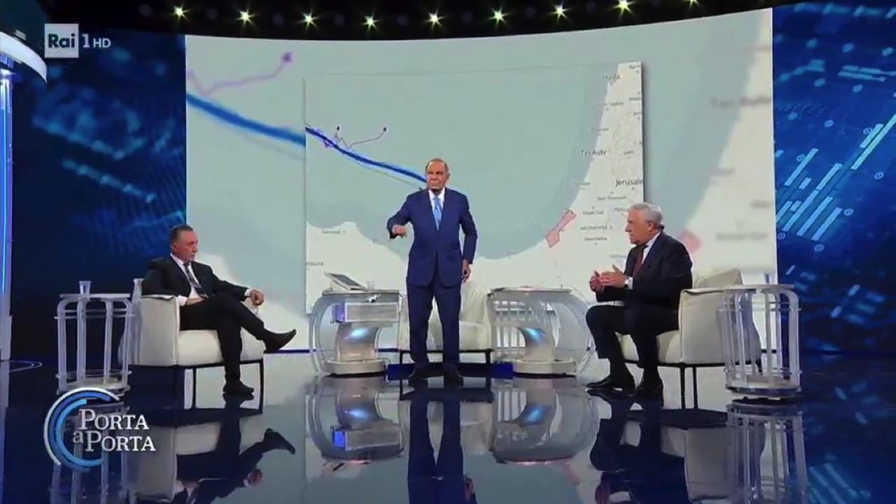 Antonio Tajani seduto nello studio di Porta a Porta, con Bruno Vespa in piedi davanti a una mappa del Mediterraneo orientale. Antonio Tajani seduto nello studio di Porta a Porta, con Bruno Vespa in piedi davanti a una mappa del Mediterraneo orientale.