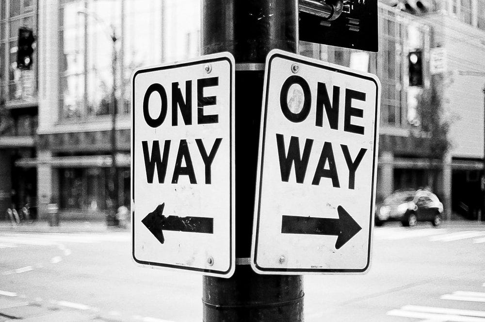 2 one-way signs point at opposite directions 2 one-way signs point at opposite directions