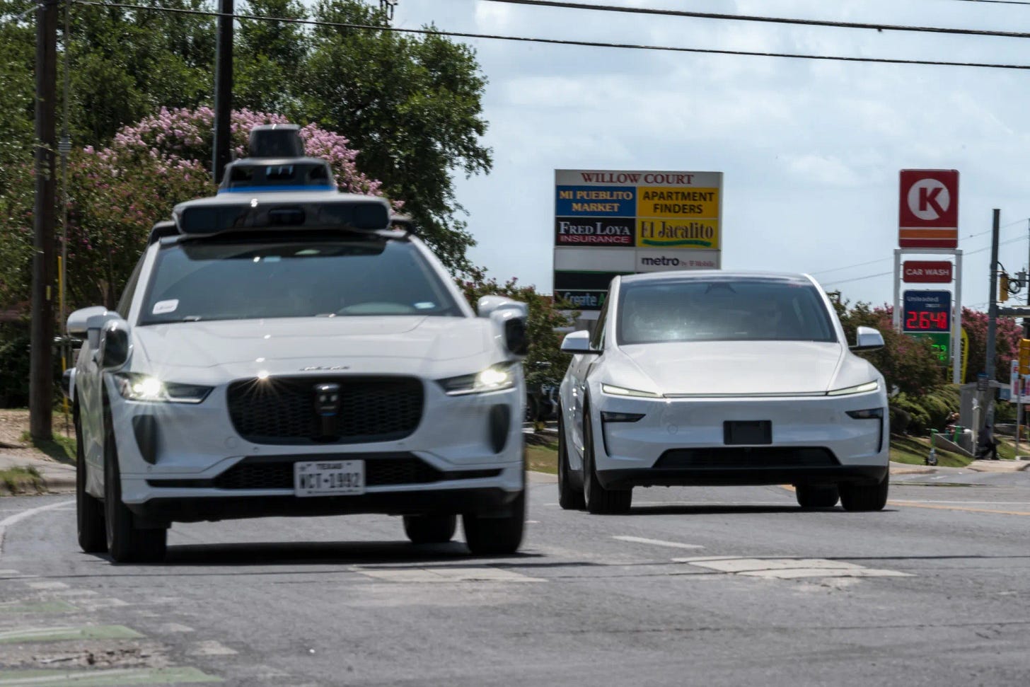 A Waymo autonomous taxi, left, and a vehicle Tesla is using for robotaxi testing purposes in Austin, Texas.