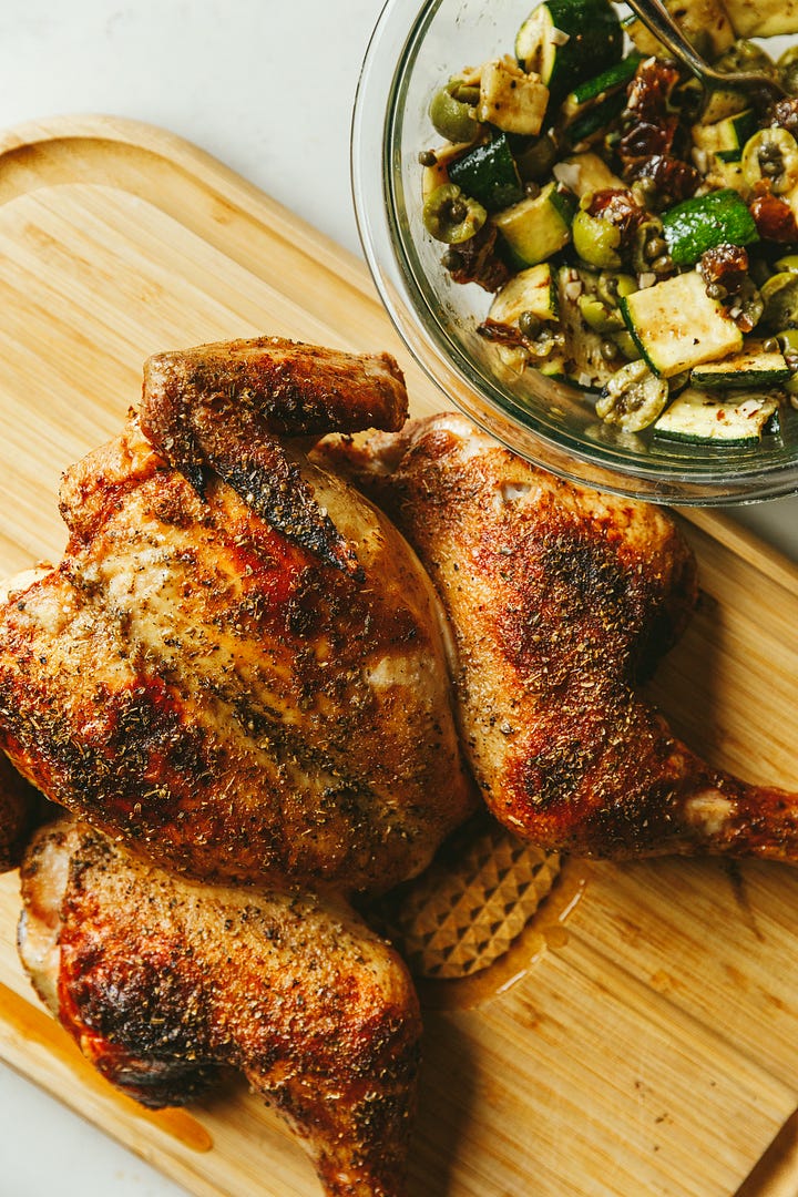 Spatchcock grilled oregano chicken and a warm zucchini salad with olives, dates, and capers.