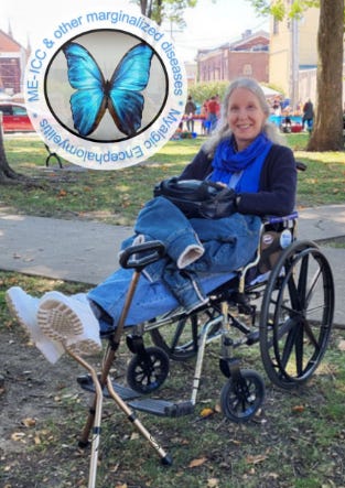 Woman sitting in a wheelchair in a park with feet on a cane/stool