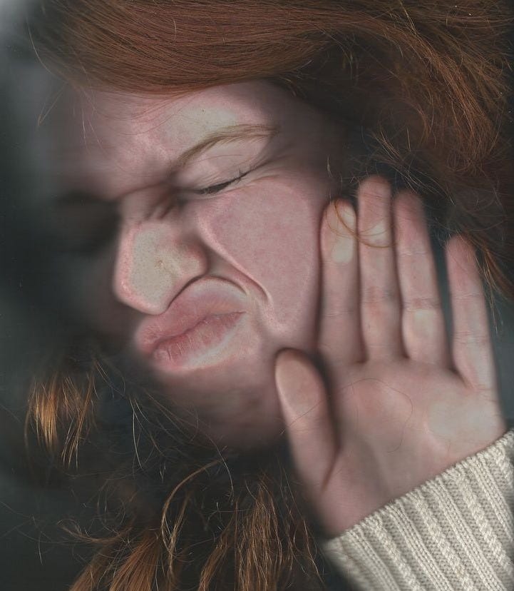 This may contain: a woman with red hair is covering her face