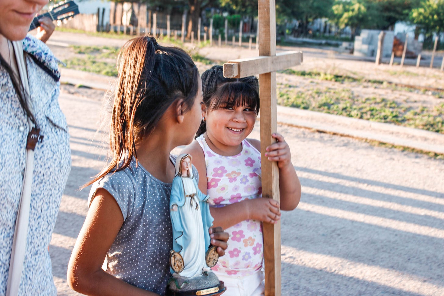 Girls holding Cross and Virgin Mary statue