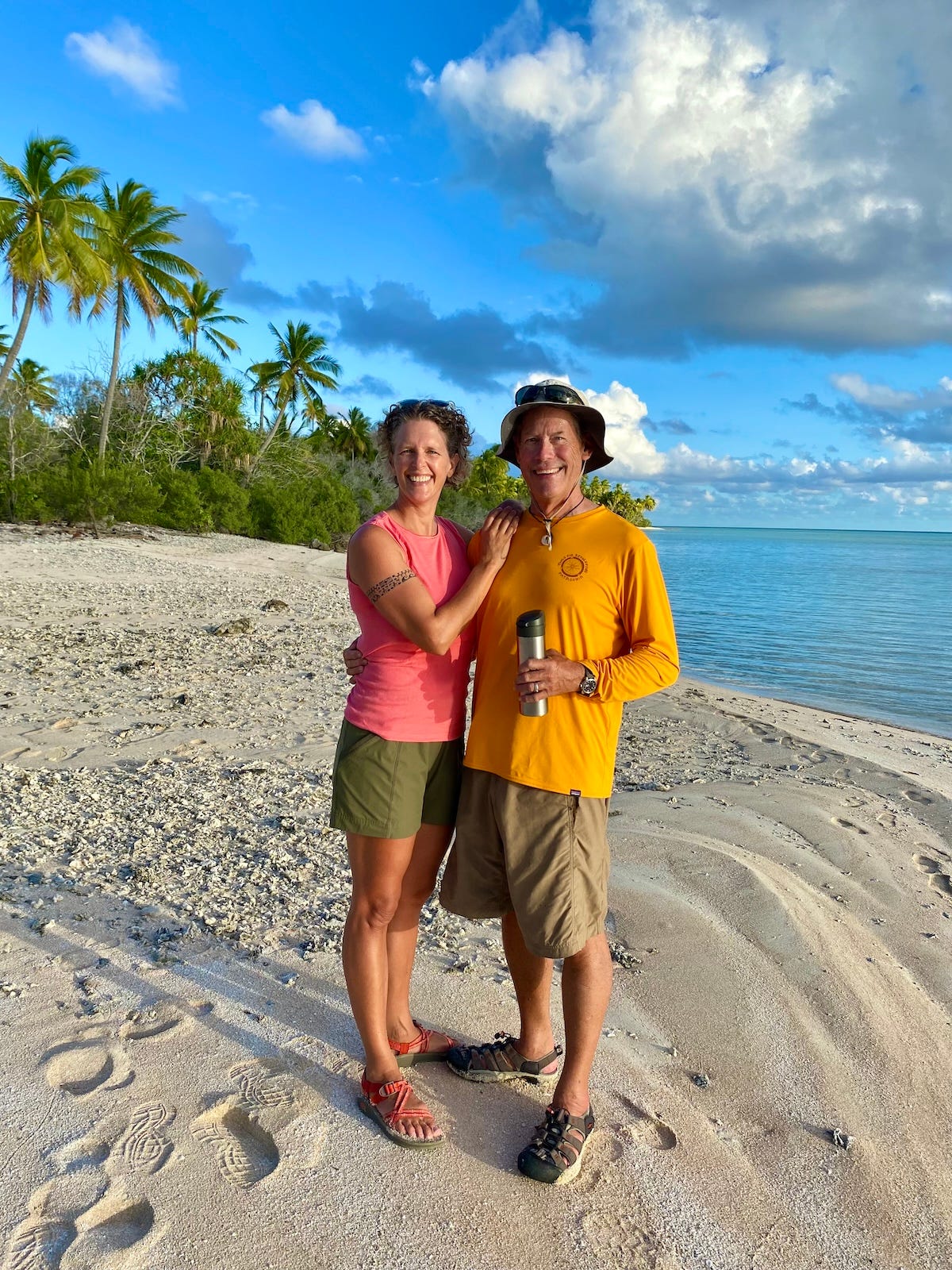 A photo of a middle-aged couple on a tropical beach, both wearing shorts and shirts, with a brilliant blue sky and blue ocean behind them A photo of a middle-aged couple on a tropical beach, both wearing shorts and shirts, with a brilliant blue sky and blue ocean behind them