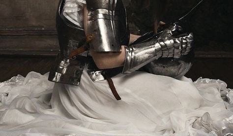 This may contain: a woman dressed as a knight kneeling down
