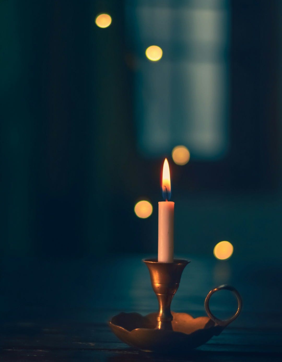 white candle lit on brass candle holder white candle lit on brass candle holder