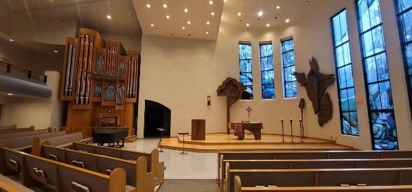 A church with a stage and benches

AI-generated content may be incorrect.