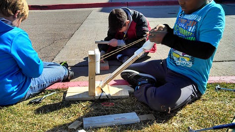 Students working on various projects throughout a classroom. 