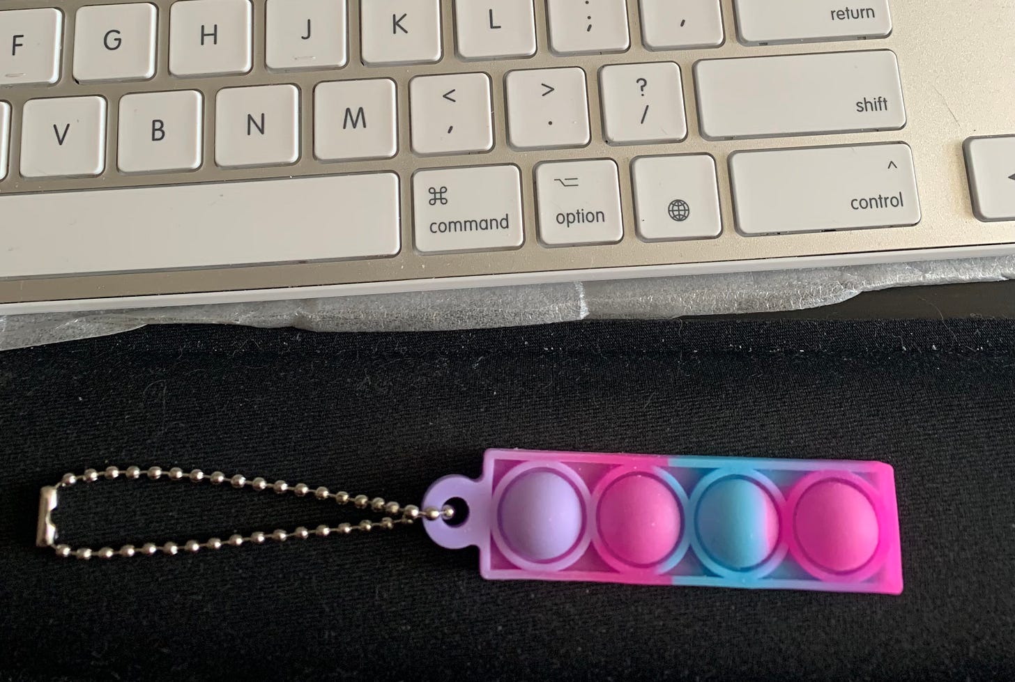 picture of part of a keyboard and a multicolored bubble fidget keychain picture of part of a keyboard and a multicolored bubble fidget keychain