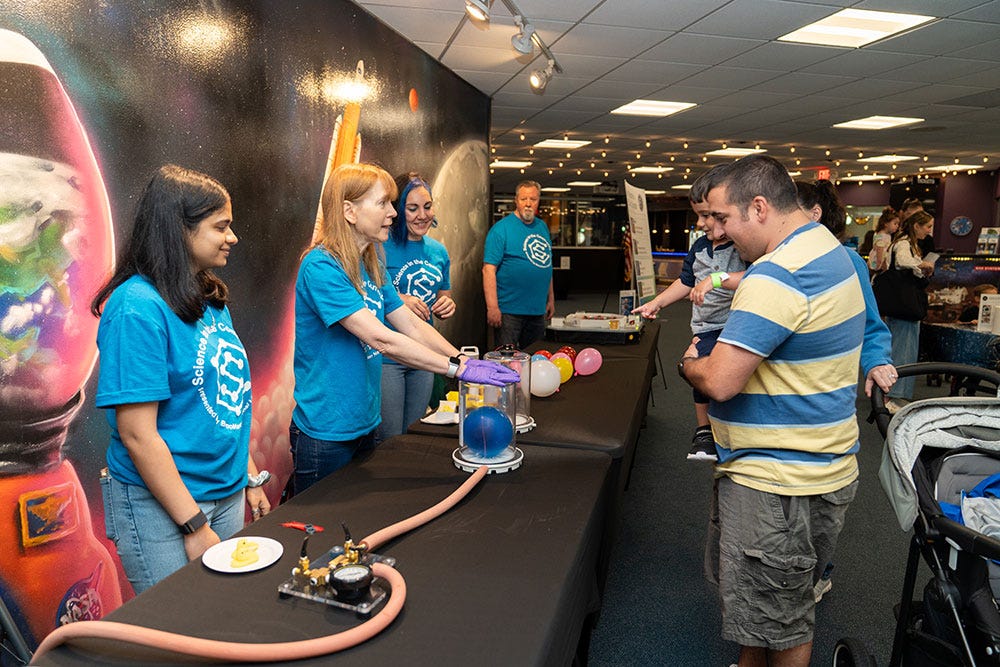photo of a Community volunteers presenting a science demonstration