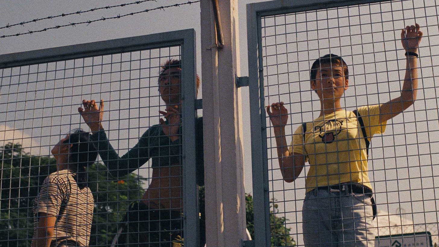 Made in Hong Kong | Still features two teenagers leaning against a fence to look over to the other side.