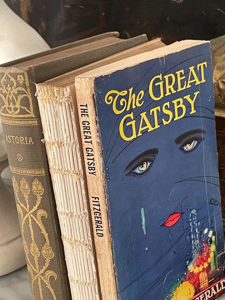This may contain: two books sitting on top of each other next to a vase with flowers in it