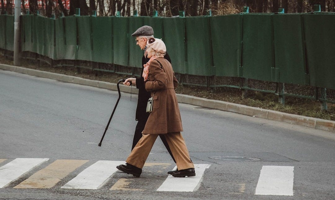 man and woman walking on pedestrian line during daytime