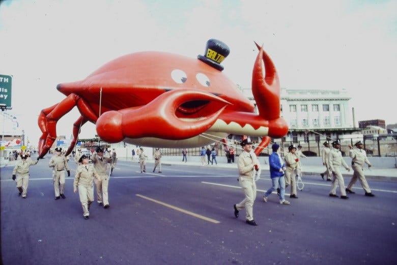 A giant inflatable crab wearing a top hat is pulled down North Charles Street by Penn Station in 1982. Image courtesy of the Baltimore Office of Promotion & Arts. A giant inflatable crab wearing a top hat is pulled down North Charles Street by Penn Station in 1982. Image courtesy of the Baltimore Office of Promotion & Arts.