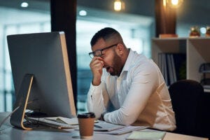 a man yawning at his desk