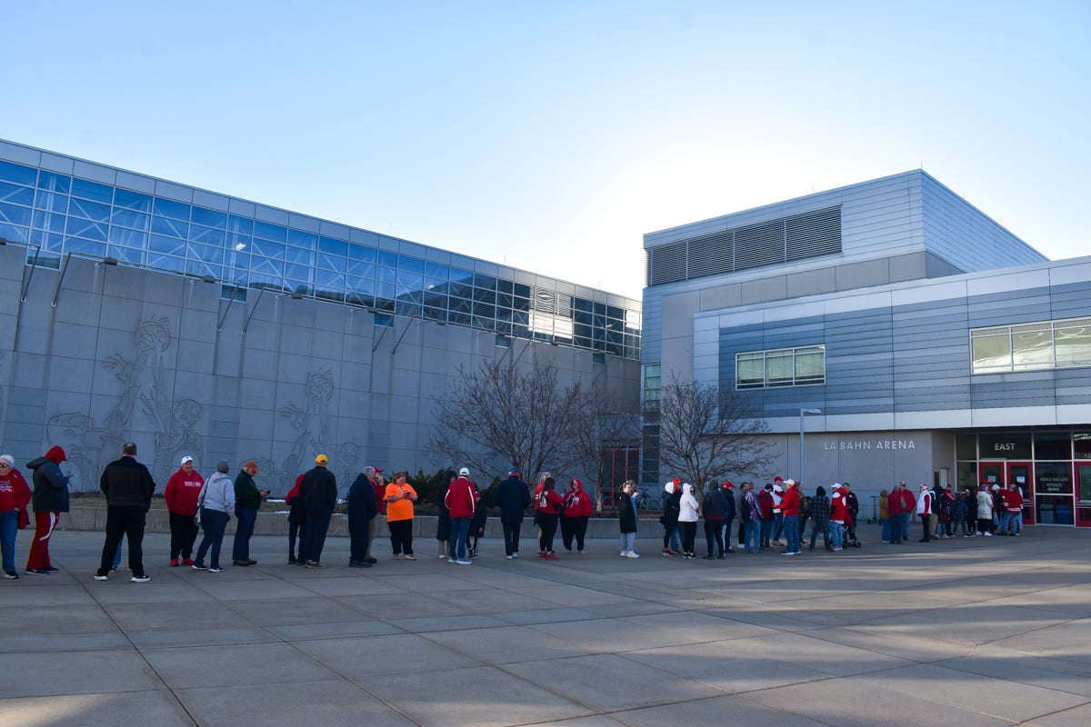 A line of people, approximately 50 people long before the frame cuts off, outside one entrance of LaBahn Arena. 