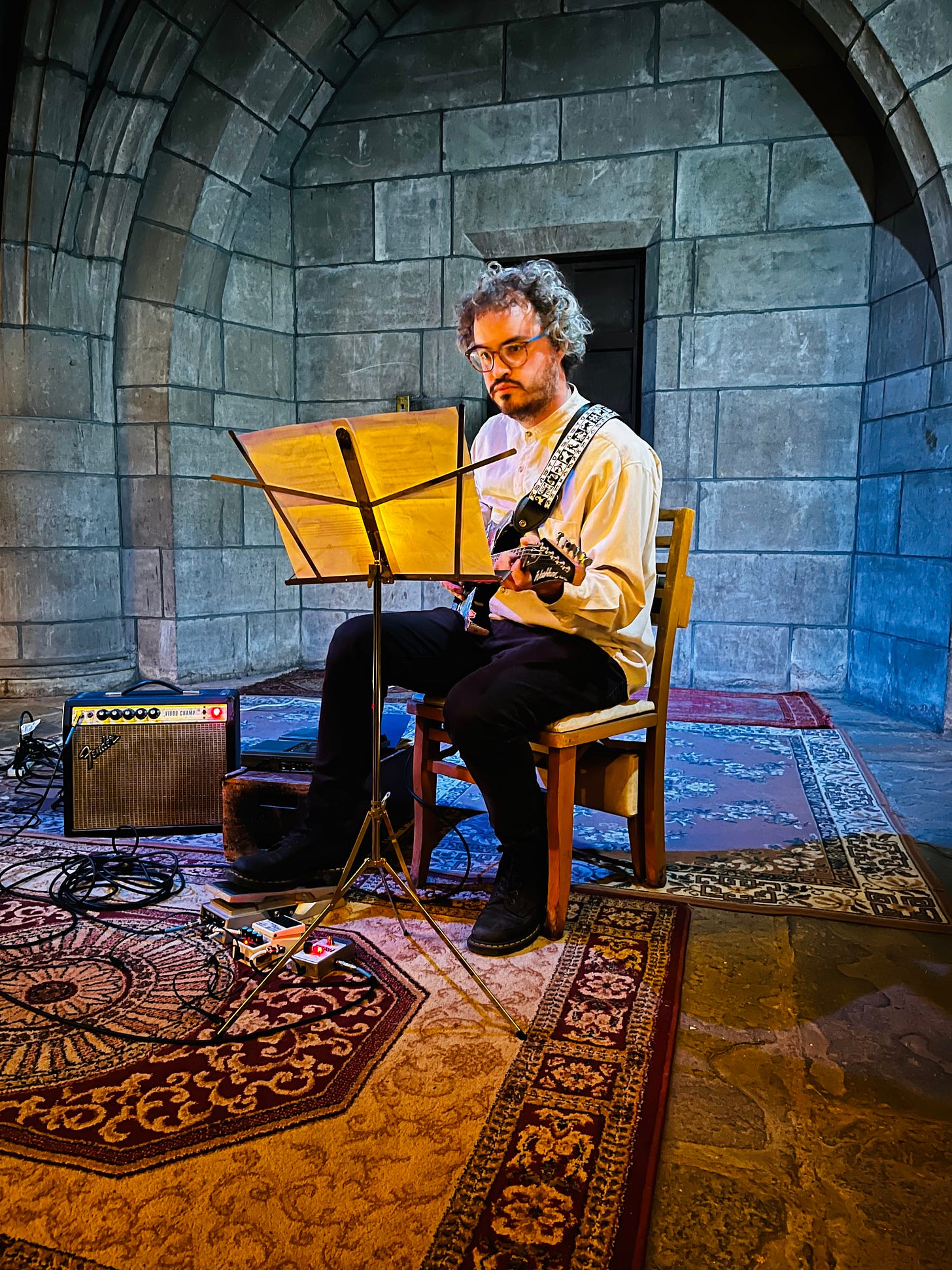 A man sits in a chair playing a guitar A man sits in a chair playing a guitar