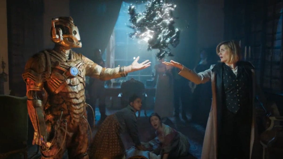 This image shows Ashad (played by Patrick O'Kane) on the left and the Thirteenth Doctor (played by Jodie Whittaker) on the right. Between them, floating in the air above Ashad's outstretched left hand and the Doctor's outstretched right hand, is the Cyberium, an artificial-intelligence database that resembles a hovering and pulsating ball of quicksilver. Yaz Khan (played by Mandip Gill) and Mary Godwin (played by Lili Miller) kneel on the floor between Ashad and the Doctor, looking surprised by the Cyberium's appearance.