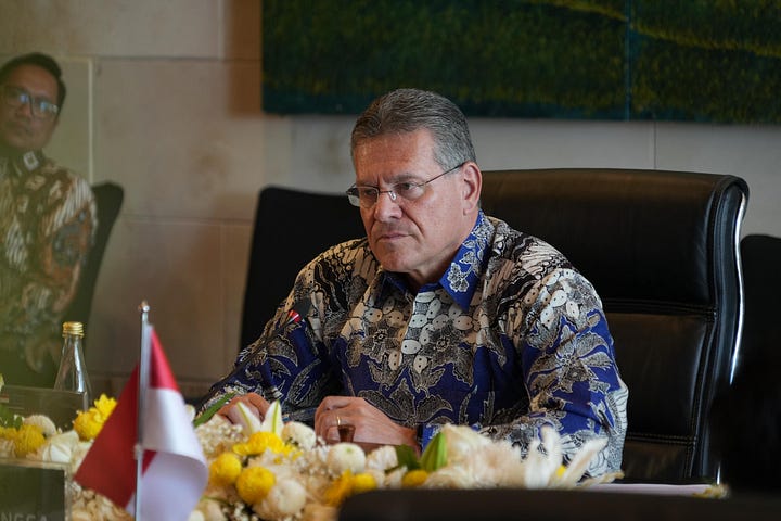 Indonesian Coordinating Minister for Economic Affairs Airlangga Hartarto shakes hands with EU Trade Commissioner Maroš Šefčovič during a bilateral meeting in Bali, September 23, 2025. Officials from both delegations are seated nearby, with flags of Indonesia and the European Union in the background.