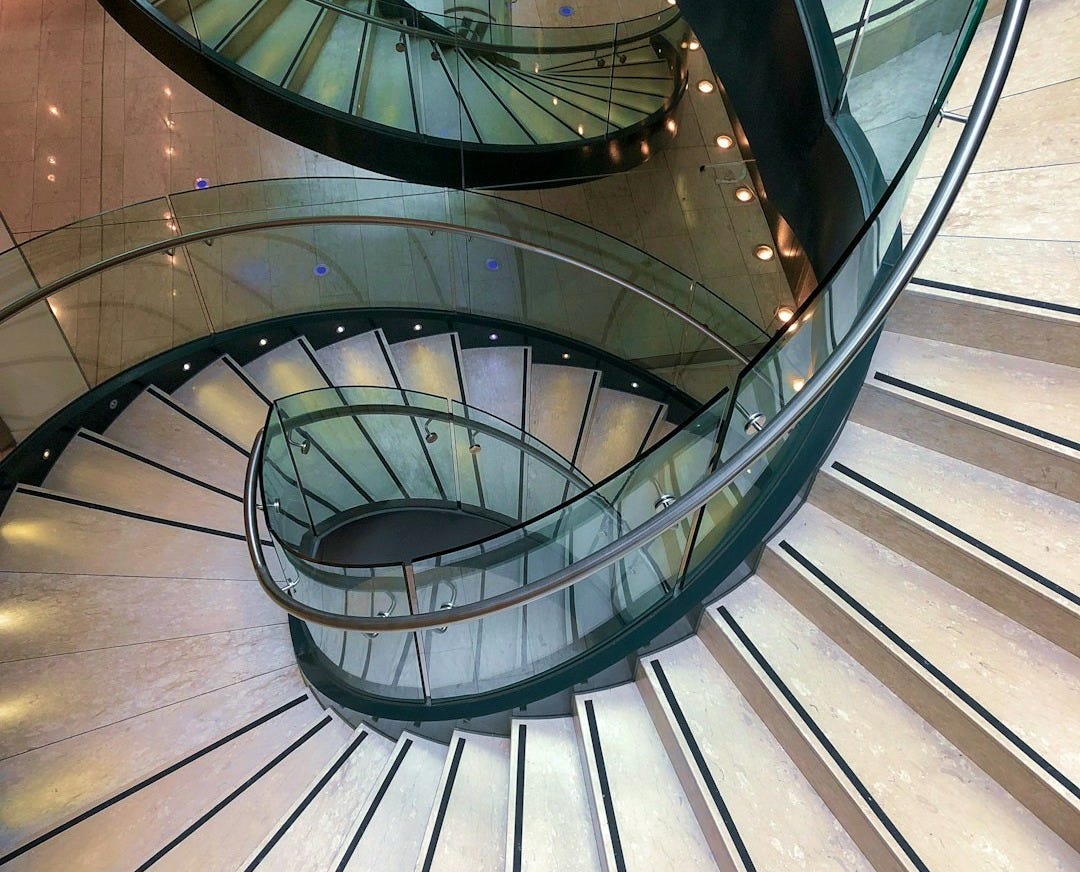 gray spiral staircase with brown wooden railings