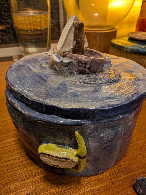 Three images of a blue ceramic container, hand-sculpted by Ahava.