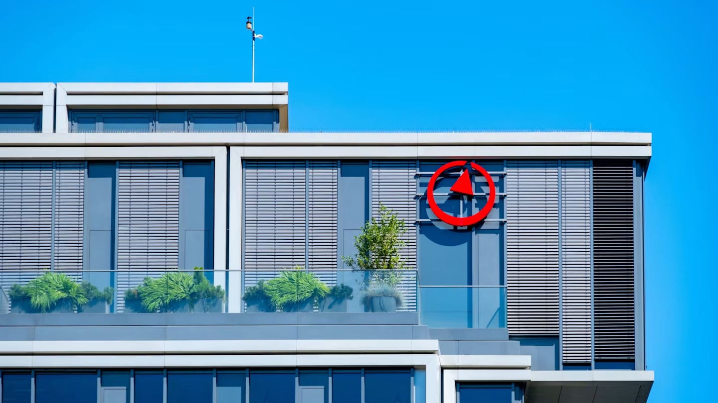 Bain & Company logo displayed on the upper floor of a modern office building with glass panels and plants. Bain & Company logo displayed on the upper floor of a modern office building with glass panels and plants.