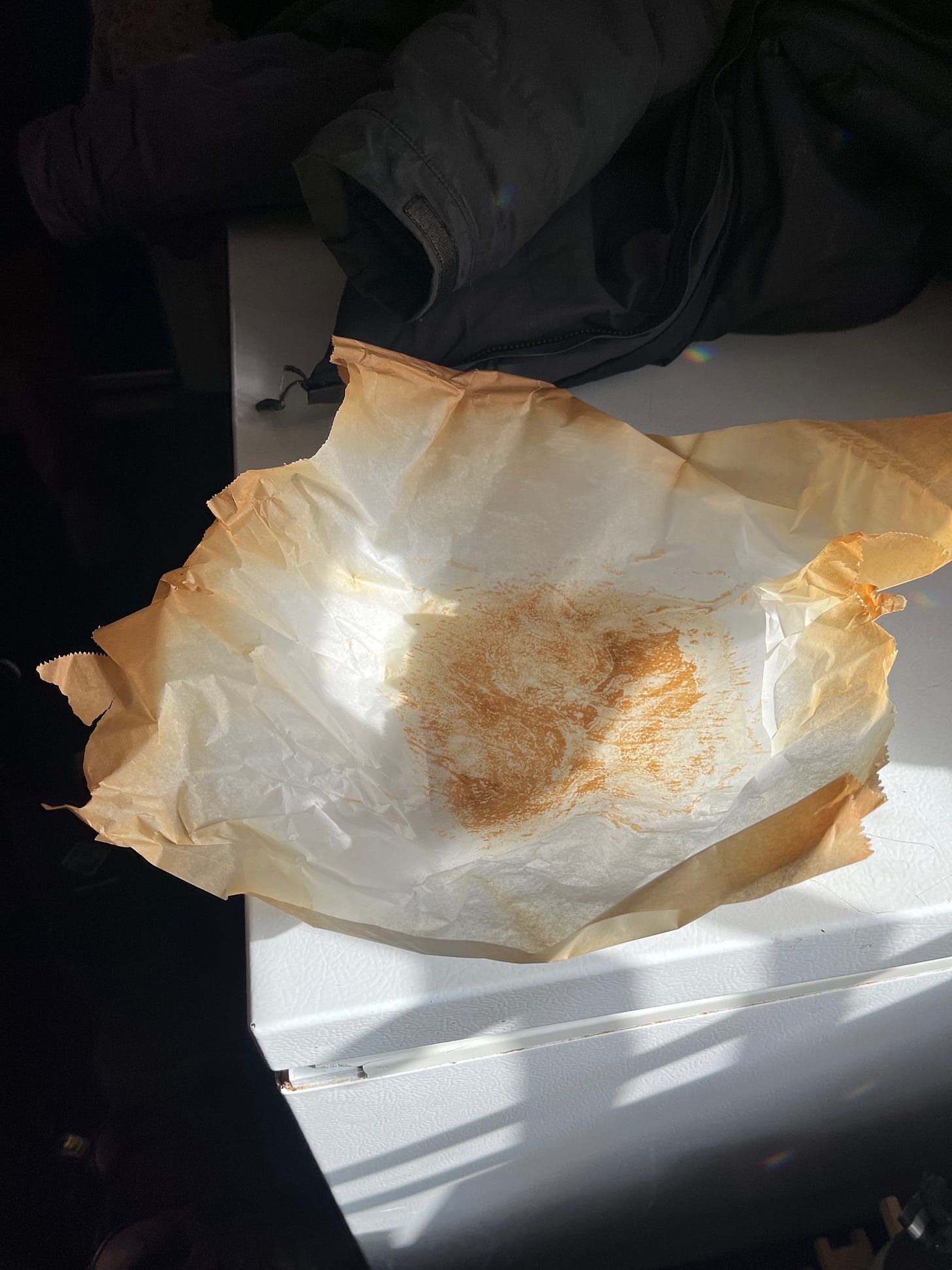 a bit of baking parchment, brown at the edges with a darker brown spot in the middle a bit of baking parchment, brown at the edges with a darker brown spot in the middle