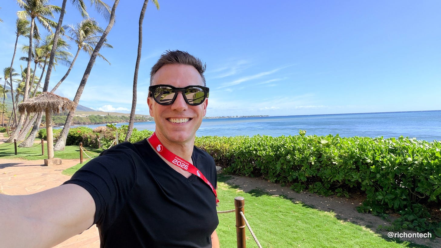 Rich takes a selfie wearing sunglasses and a Snapdragon Summit 2026 lanyard, with palm trees, green landscaping and the blue ocean behind him in Maui.