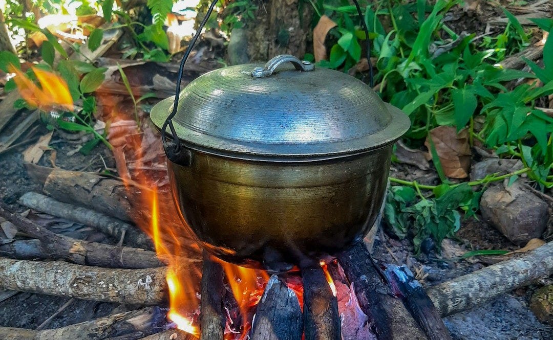 a large pot sitting on top of a fire
