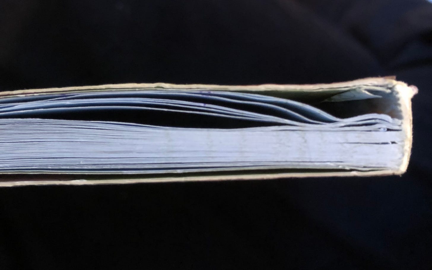 A close up view of the top edge of the same notebook from a different angle. You can also see here how many pages have been torn from the journal.