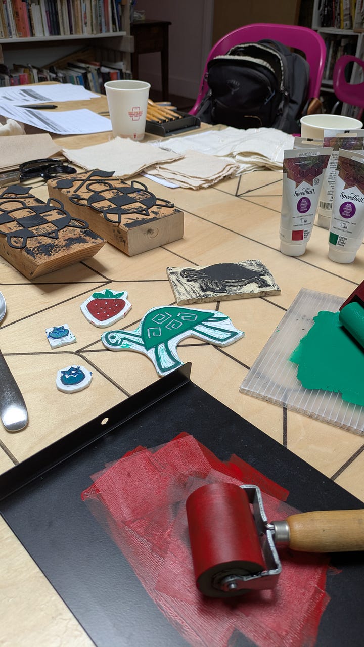 Photo 1: Linocut blogs and ink with rollers on table, Photo 2: 2 workshop participants holding shirts that they have block printed