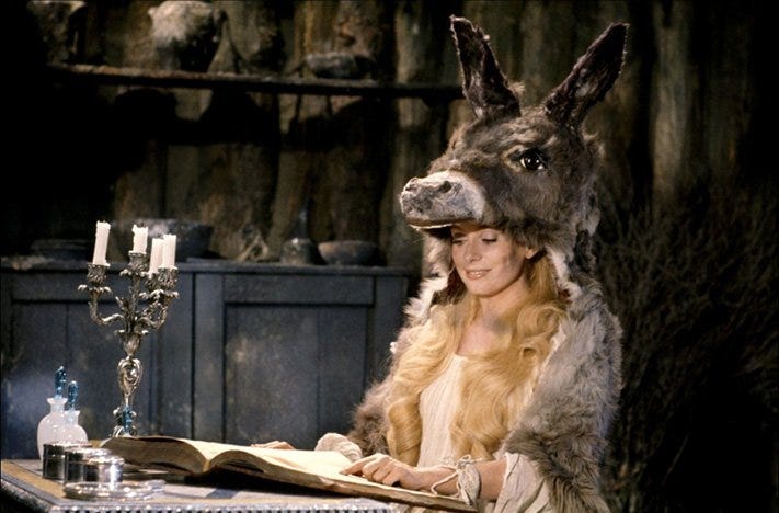 Catherine Deneuve, wearing the titular donkey skin while reading a book