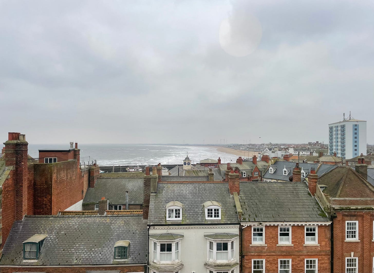 A view over the rooftops of Bridlington, the beach visible in the distance. The weather is grey.