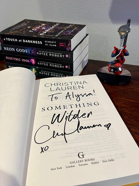 Meeting Christina Lauren, a signed copy of Something Wilder, and a stack of romance books I had signed