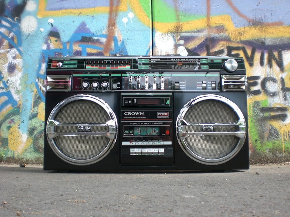 Free Classic vintage boombox placed in front of a vibrant graffiti-covered wall. Perfect for retro lovers. Stock Photo