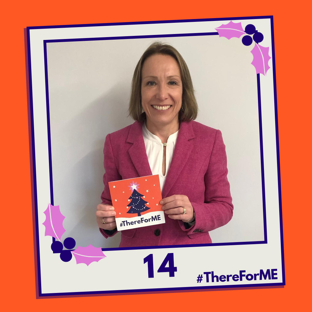 A pretend polaroid shows a smiling Helen Morgan MP posing for a photo holding a #ThereForME Christmas card.   The image on the card shows the dark blue Christmas tree, decorated with sparkling fairy lights, baubles and a star on the top, in a snowy landscape against a starry backdrop. The design is in the #ThereForME colours.