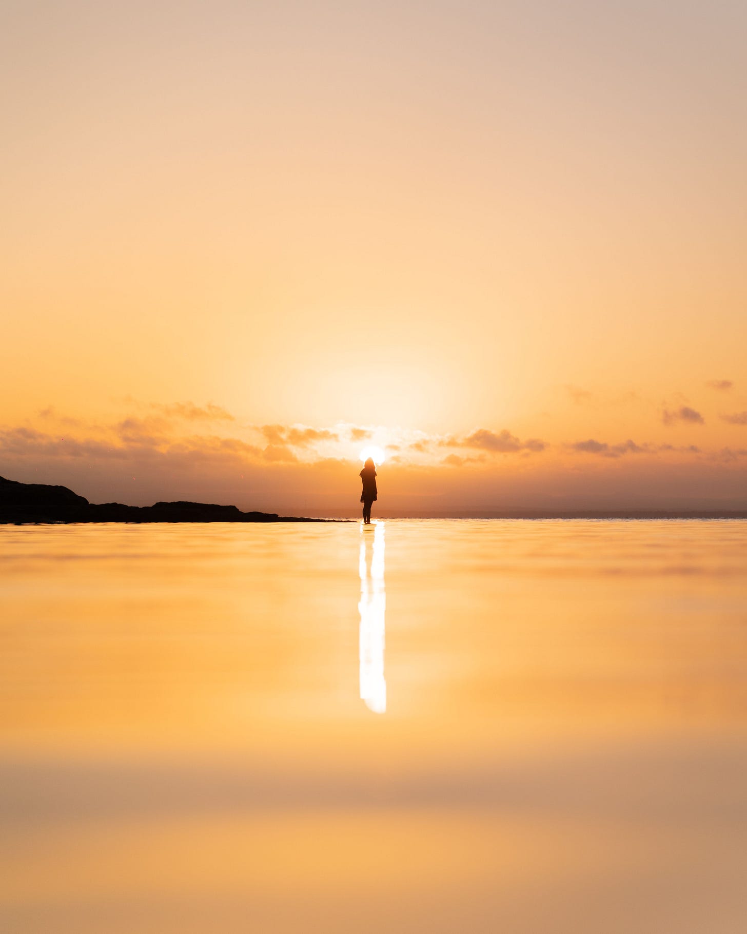 Silhouette of a person standing by the ocean at sunset, with warm hues and a tranquil atmosphere for Kay Fabella's Edgewalkers Collective on Substack for When Your Life Abroad Looks Settled essay Silhouette of a person standing by the ocean at sunset, with warm hues and a tranquil atmosphere for Kay Fabella's Edgewalkers Collective on Substack for When Your Life Abroad Looks Settled essay