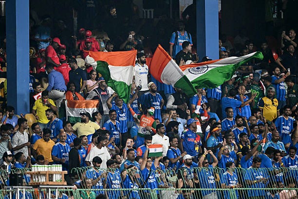 Fans wave India's national flag as they cheer from the stands during the 2026 ICC Men's T20 Cricket World Cup group stage match between India and...