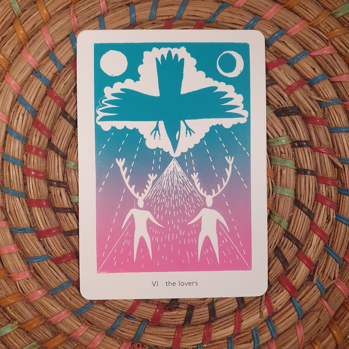 The Lovers tarot card from the Queer Crow Death Magic Tarot by Frank Duffy, showing two figures beneath a crow and storm-cloud sky, photographed during Lucy Rose’s Tarot DMs interview where she reflects on choice, desire, collaboration, and the creative tensions behind her Sunday Times bestselling novel The Lamb.