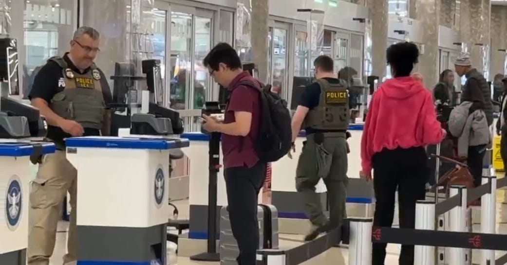 ICE agents check passenger IDs on Thursday at a security checkpoint at  Hartsfield-Jackson Atlanta International Airport.