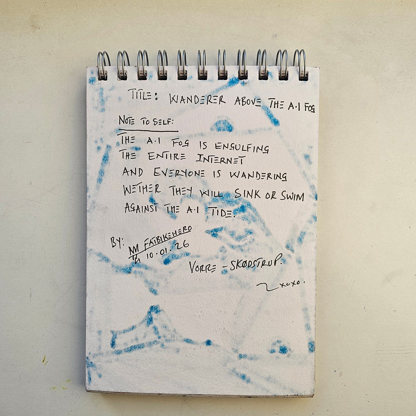 The verso of a sketchbook page featuring handwritten notes in black ink by FatbikeHero. The text reads "TITLE: WANDERER ABOVE THE A.I FOG" followed by a "NOTE TO SELF" about the internet being engulfed by an AI tide. Significant blue ink bleed-through from the front artwork creates a textured backdrop. The verso of a sketchbook page featuring handwritten notes in black ink by FatbikeHero. The text reads "TITLE: WANDERER ABOVE THE A.I FOG" followed by a "NOTE TO SELF" about the internet being engulfed by an AI tide. Significant blue ink bleed-through from the front artwork creates a textured backdrop.