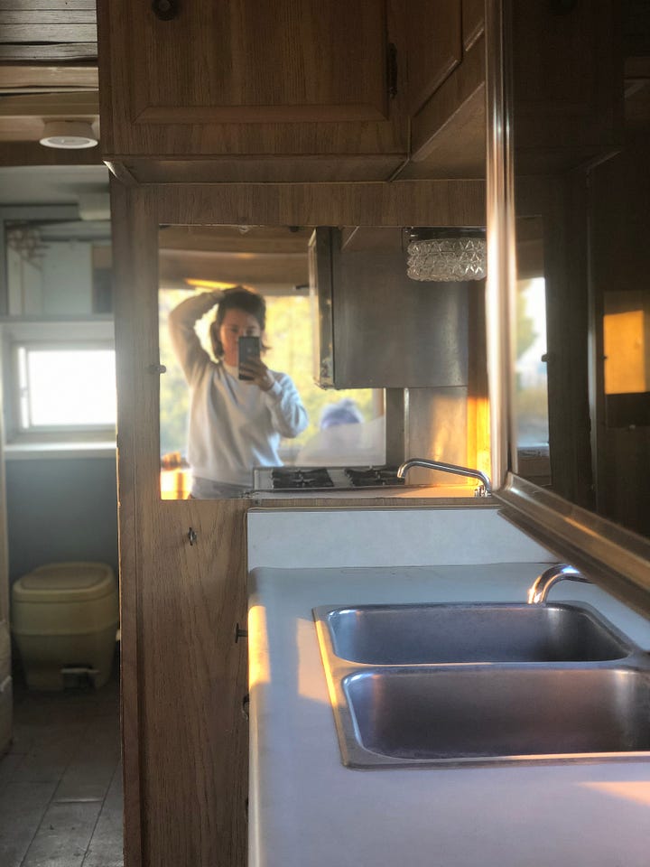 One row of two photos, left to right: Photo of woman and man standing talking determinedly in the wooden interior of an RV camper; cell phone mirror selfie of woman in an RV camper with bathroom in the background and kitchen sink in the foreground.