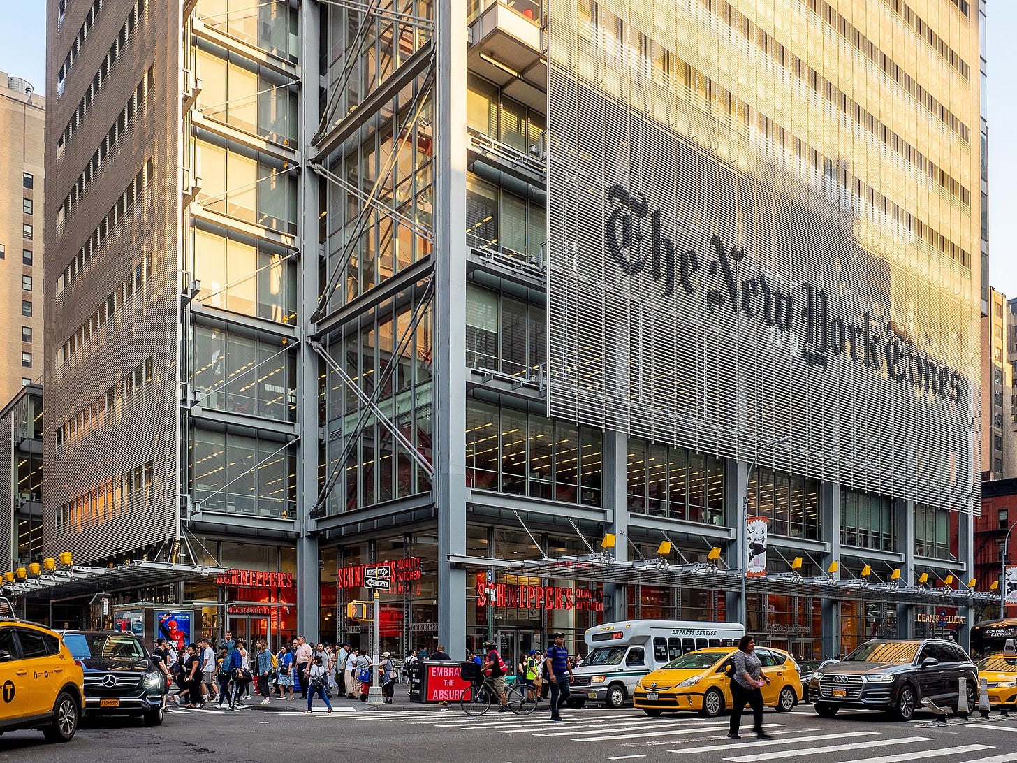 New York Times building, logo on outside, lots of people and cars outside New York Times building, logo on outside, lots of people and cars outside