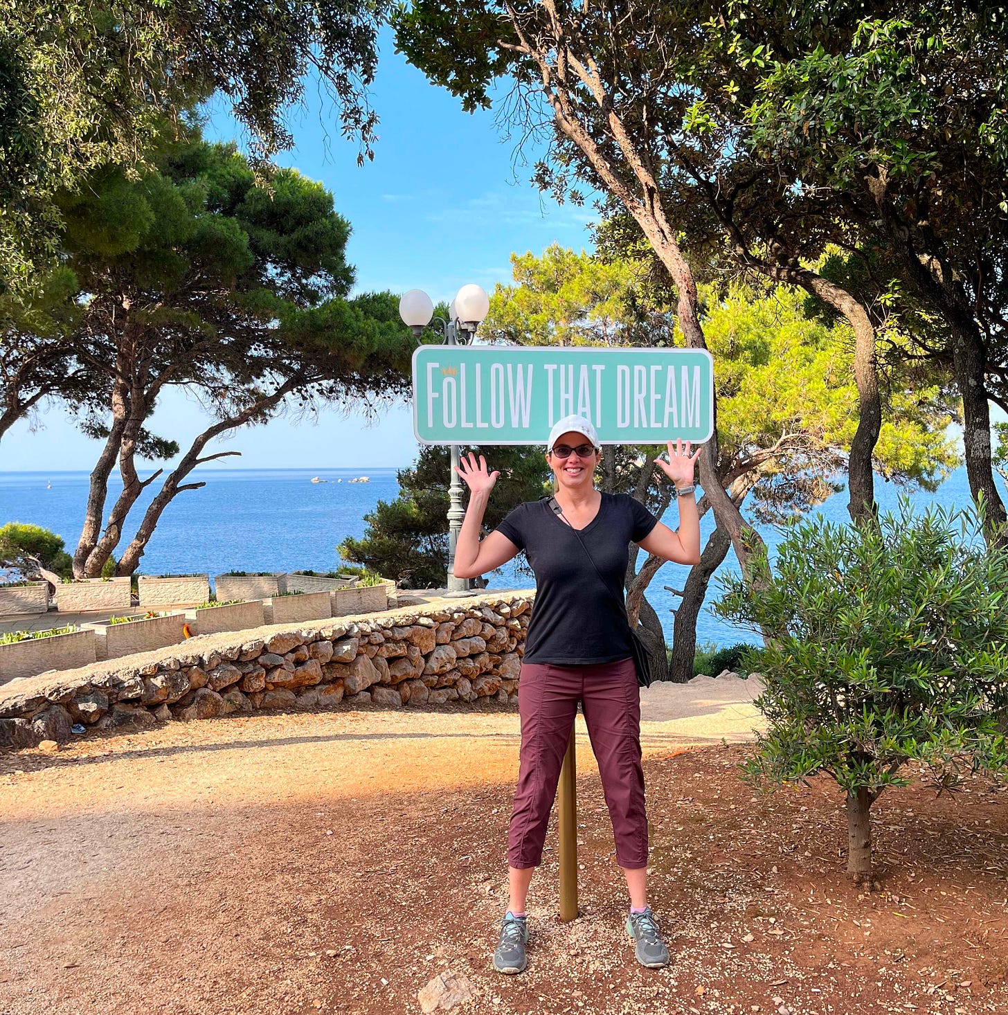 a woman standing in front of a sign that says Follow That Dream a woman standing in front of a sign that says Follow That Dream