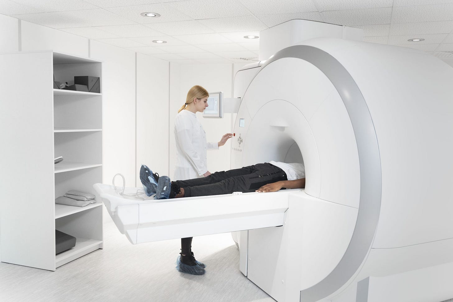 young doctor pressing ct scan buttons scaled