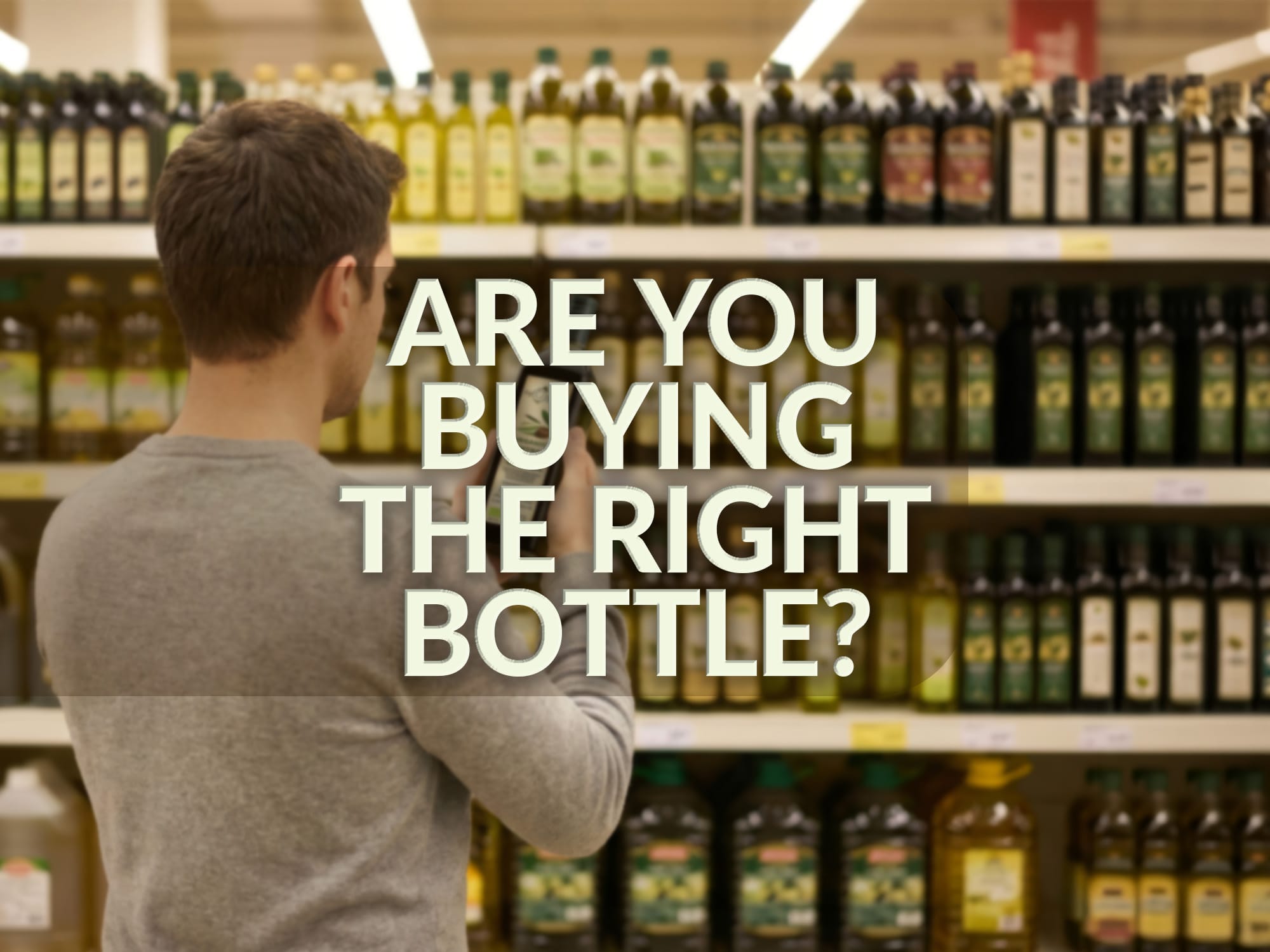 A young man stands in a supermarket trying to choose between dozen of different bottles of extra virgin olive oil