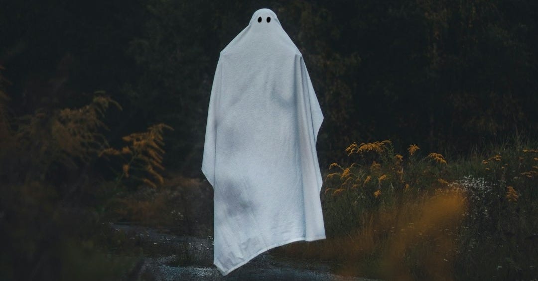 a white ghost standing in the middle of a forest a white ghost standing in the middle of a forest