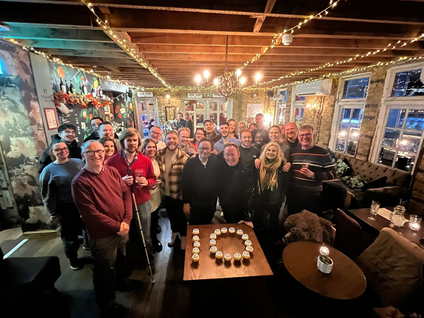 May be an image of 5 people, table, lighting, dartboard and crowd