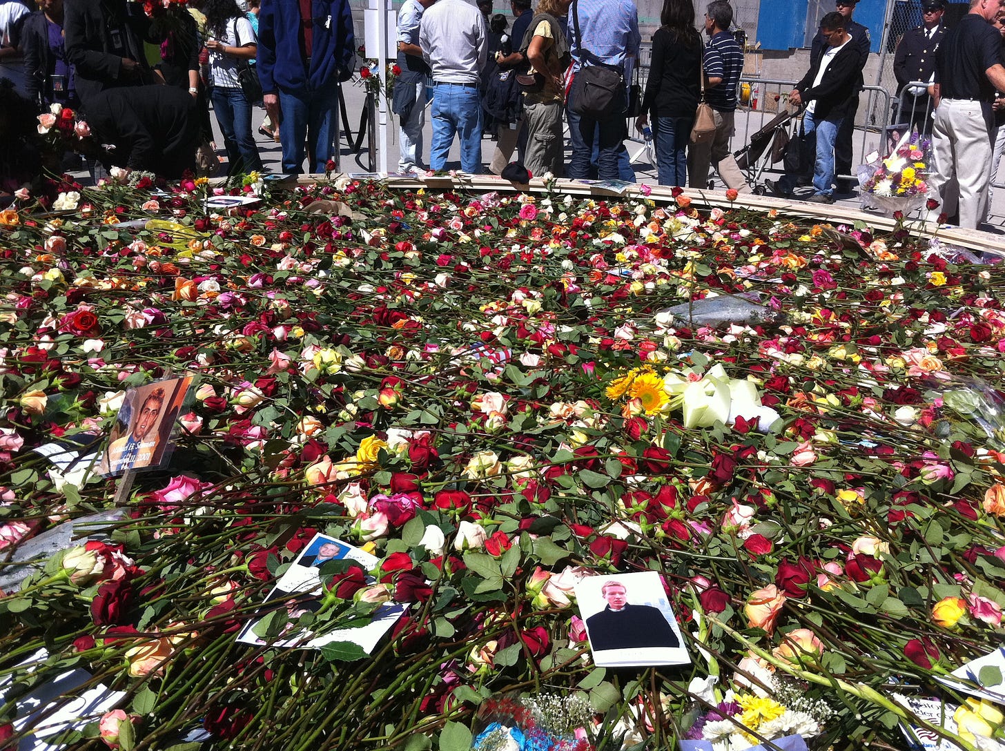 Circle of Honor at Ground Zero on September 11, 2002, a temporary memorial inside the open site where families placed roses and photographs, including a visible photo of David Tengelin, in remembrance of victims of the World Trade Center.